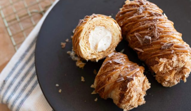 Cannoncini, also known as cream horns, are an Italian rolled puff pastry treat with a sweet cream filling. Our Biscoff Caramel Cannoncini features house-made puff pastry and a luscious Biscoff salted caramel pastry cream, with a drizzle of salted caramel for good measure!
